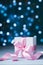 Gift box or present with pink bow ribbon against magic bokeh background. Greeting card for Christmas, New Year or wedding.