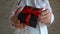 Gift box with red ribbon in female doctors hands, christmas, black friday, birthday