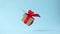 Gift box with red ribbon spinning on blue background. 360 degree rotation. seamless loop. zero gravity. levitation. Concept sales,