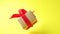 Gift box with red ribbon spinning on yellow background. 360 degree rotation. zero gravity. levitation. copyspace. Concept sales, d