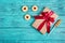 Gift box with a satin bow on a blue wooden background. A present, a cookie with marmalade and a lollipop. Holiday romantic concept