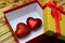 In the gift box are two red hearts