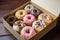 A gift box of various glazed donuts. Promotional commercial photo.