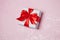 Gift box vith red bow and glitter sparkles on pink background. st. Valentine`s day concept