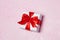 Gift box vith red bow and glitter sparkles on pink background. st. Valentine`s day concept