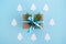 Gift box wrapped of craft paper, blue and white ribbons and decorated fir branches and pinecones on the blue background, top view.