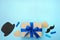 Gift box wrapped in karft paper with blue ribbon, hearts, mustache, black hat on blue background