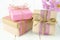 Gift boxes with brown and pink wrapping on white wood