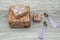 Gift boxes with large purple earrings on a gray wooden background.