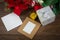 Gift boxes with paper card and Christmas leaf on table.