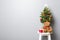 Gift boxes, teddy bear and small decorated Christmas tree on stool chair