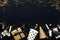 Gift boxes in various gold pattern wrapping papers and party accessories over star shaped golden sequins on a black background
