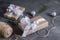 gift boxes wrapped in Kraft paper, with white ribbon and rope, silver balls, reel with rope on gray background