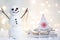 Gift card with a new year and christmas with a picture of a snowman with a sleigh against a backdrop of glowing garlands