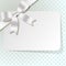 Gift card with white pearl ribbon on a turquoise polka dot background.