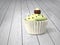 Gift cupcake with pistachio cream and chocolate balls on cold white wood