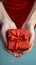 Gift elegance Womans hands holding a red gift with ribbon