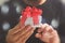 gift giving,man hand holding a gift box in a gesture of giving.blurred background,bokeh effect