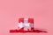 A gift in kraft box with a red bow on a red background with hearts. Surprise your loved one. The concept of the day of St.