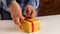 Gift making industry. Women`s hands stick a beautiful bow on a gift box. Woman wrapping a surprise festive present in workshop.