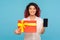 Gift order online. Portrait of happy smiling woman with fancy red hair showing wrapped box and cellphone