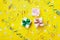 Gift or present box decorated colorful confetti, star, candy and streamer on yellow table top view. Flat lay style. Birthday.