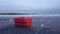 Gift with ribbon and bow on wet sand against running waves