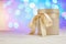 Gift round box with satin ribbon bow on blurred bokeh background. Greeting card or banners copyspace