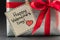 Gift in silver packaging with red ribbon and greetings with Valentine`s day