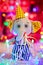 Gift toy elephant in cap stand on background of Christmas lights and boxes