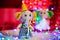 Gift toy elephant in yellow cap stand on background of Christmas lights and boxes