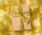 Gift wrapped in brown paper on a twisted golden ribbon background, festive background