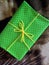 The gift is wrapped in green paper and tied with twine