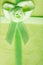 Giftbox closeup. Ribbon with bow on green background