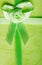 Giftbox closeup. Ribbon with bow on green background