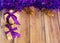 Gifts are packed in kraft paper and tied with a satin ribbon with Christmas toys and purple tinsel on a wooden background. Decor f