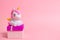 Gifts, unicorn figurine and gift box for a party on a pink background