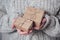 Gifts in women`s hands, close-up. Monochrome, minimalist gift concept. A girl in a sweater holds gift boxes made of Kraft paper,