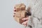 Gifts in women`s hands, close-up. Monochrome, minimalist gift concept. A girl in a sweater holds gift boxes made of Kraft paper,