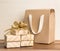 Gifts wrapped in natural craft paper on wooden table on bright b