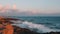 Gigantic ocean waves crashing on rocky beach. Big sea waves splashing and creating foam. Stormy mediterranean sea at sunset. Massi