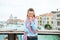 Giggling woman tourist on Bridge with arms crossed