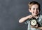 Giggling young child showing retro alarm clock for time concept