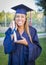 Giggling Young Teen Holding Diploma in Cap and Gown