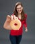 Giggling young woman grabbing a donut as junk food temptation