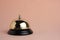 Gilded bell hotel service on pastel beige background, isolated.Conceptual hotel, travel and recreation