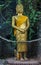 Gilded Buddha Statue stands in a tropical forest
