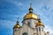 Gilded domes of orthodox Christian church shine on the blue sky