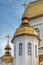 Gilded domes of orthodox Christian church shine on the blue sky