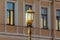 Gilded elegant vintage street lamp on the background of windows.